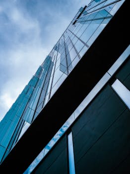 Discover modern urban architecture through this low angle shot of a sleek building exterior.