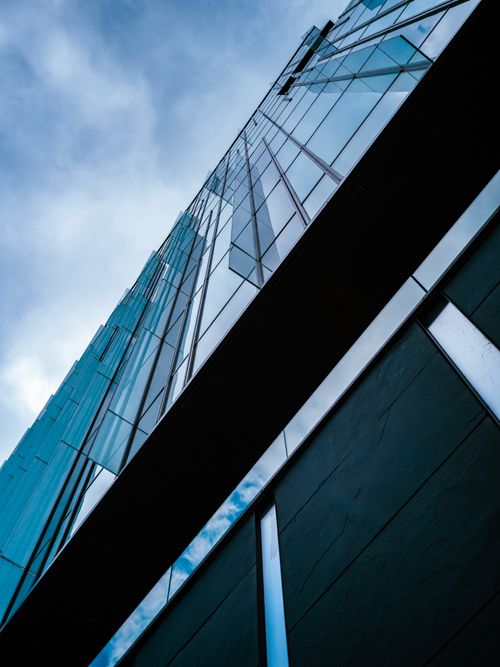 Free Discover modern urban architecture through this low angle shot of a sleek building exterior. Stock Photo