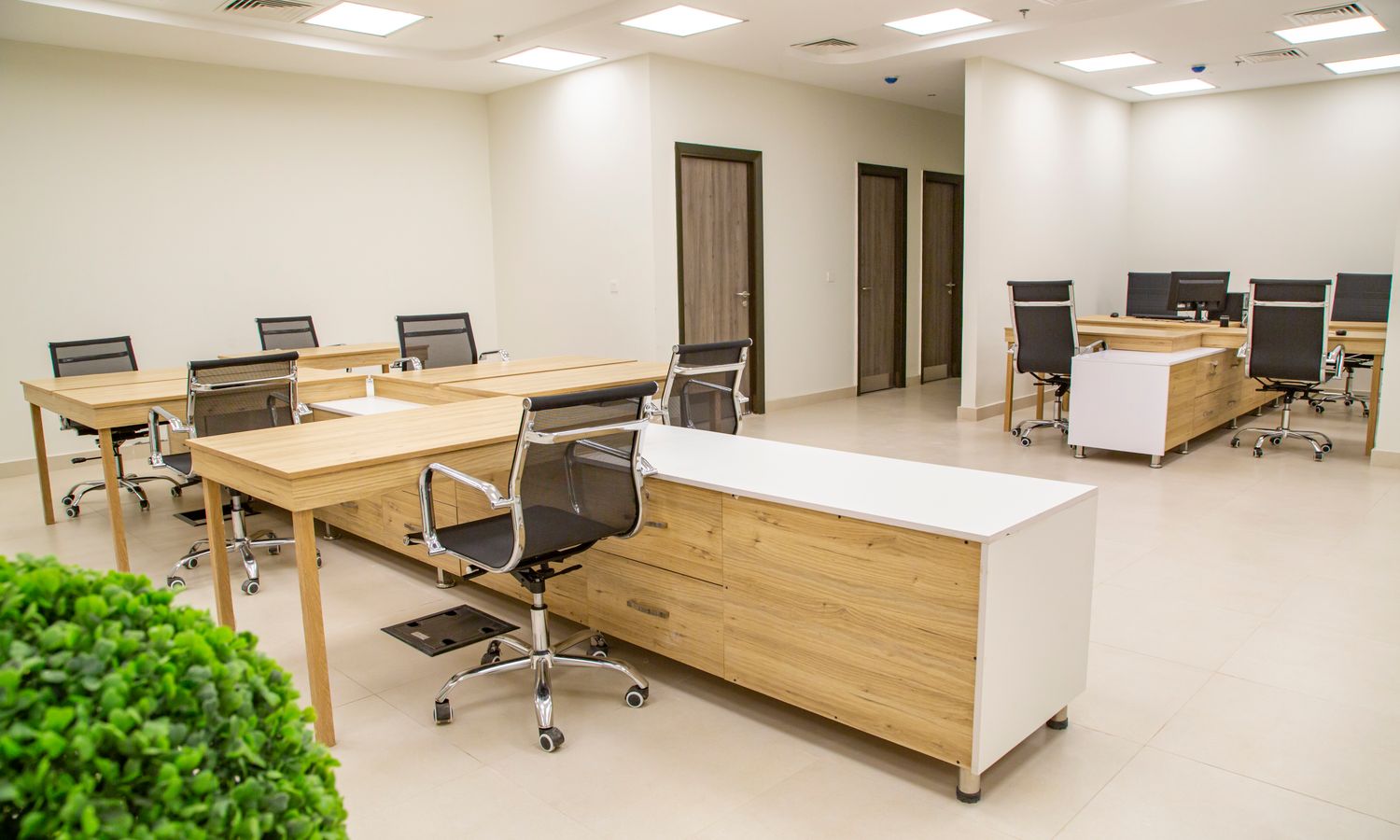 Oficina vista desde arriba con mesas de madera y sillas ergonómicas