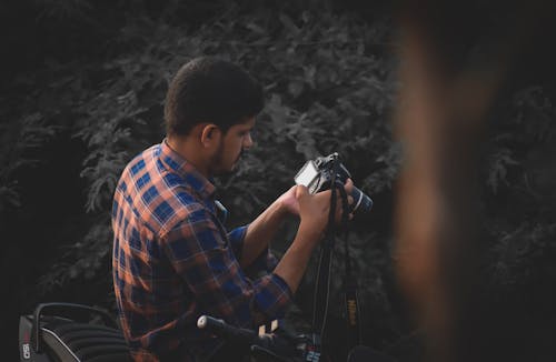 Photo of a Man in a Striped Shirt Looking at his Camera