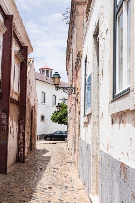 Explore a charming cobblestone alley in the historic city of Faro, Portugal.