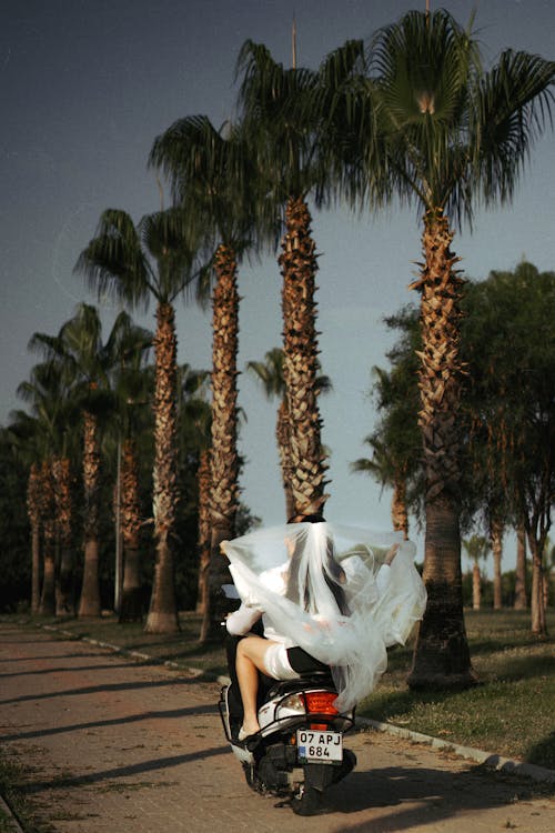 Bride and Groom Driving Away on a Scooter 