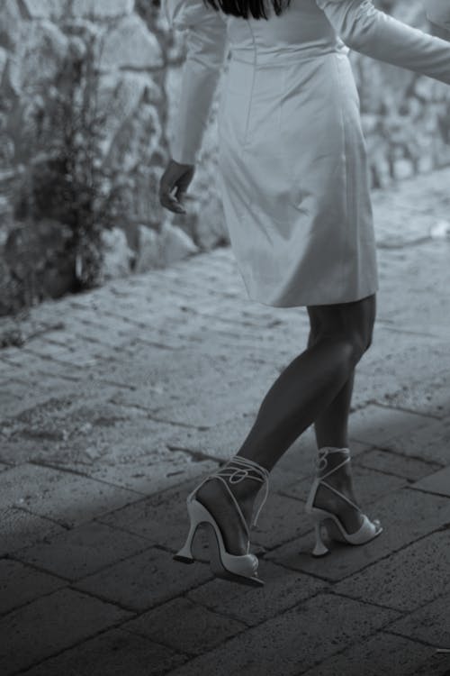 Elegantly Dressed Woman in a Dress and High Heels Walking 