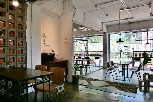 Free Cozy café interior featuring modern industrial design, spacious layout, ideal for relaxation or work. Stock Photo