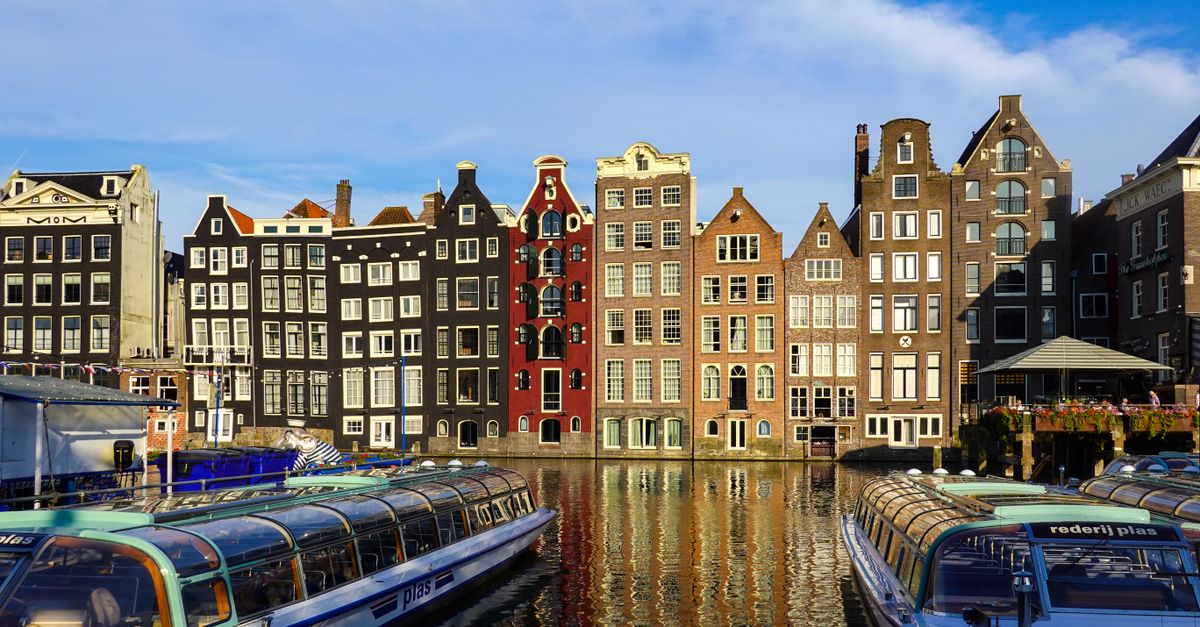 Colorful historic canal houses and boats along an Amsterdam canal