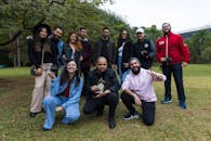 A Group of People on Green Grass Near Tree