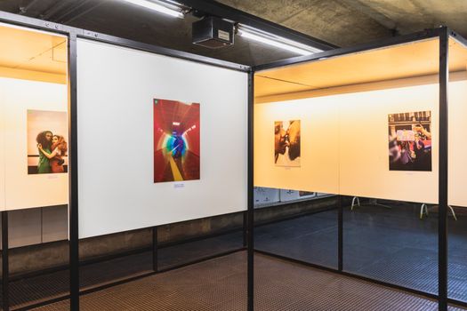 A modern art gallery featuring contemporary photographs on display under bright lighting.