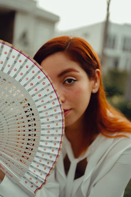 A Woman Covering her Face with the Hand Fan