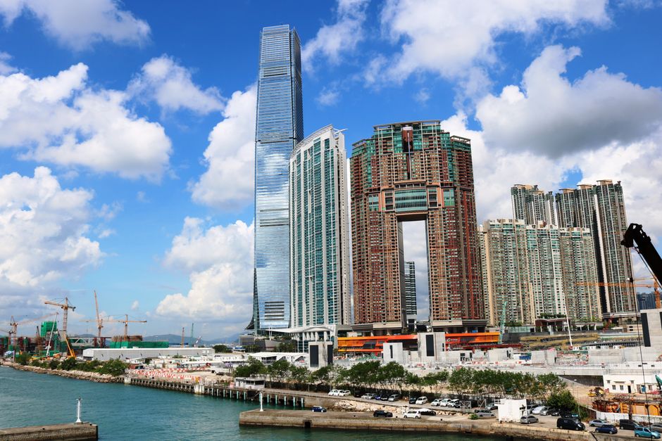 Stunning view of Hong Kong Stunning view of Hong Kong's harborside skyline with iconic skyscrapers under a bright blue sky.