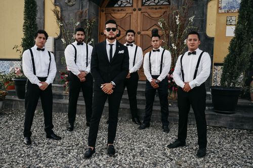 Free Six groomsmen in stylish attire pose confidently outdoors before a wedding in Ecuador. Stock Photo