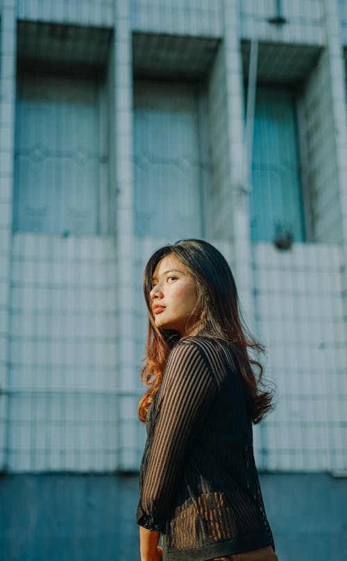 A Woman in Striped Long Sleeves Looking Over Shoulder