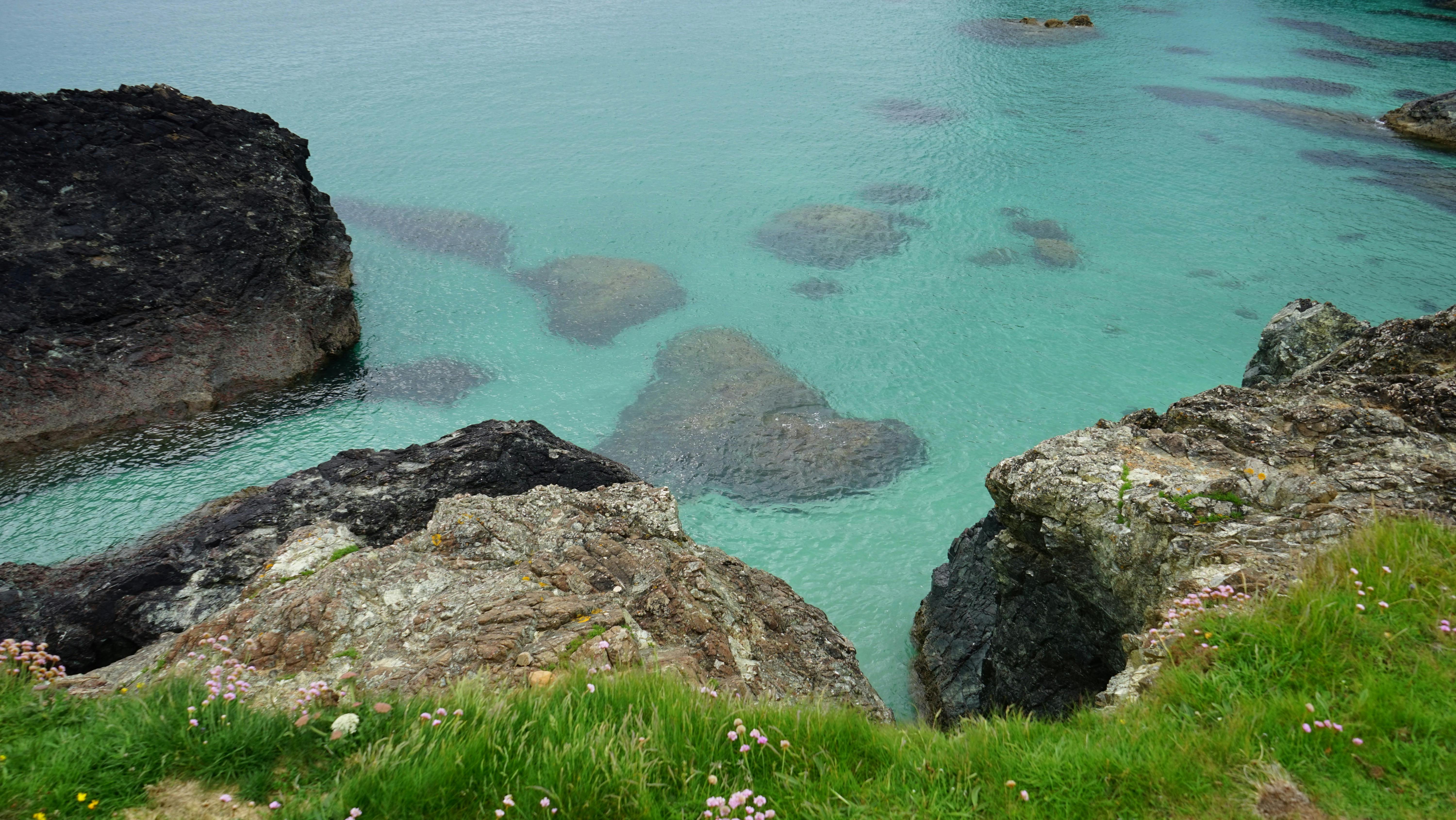 Brown Cliff Near Calm Body of Water · Free Stock Photo