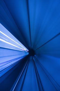 Dynamic motion blur of a blue tunnel creates a captivating futuristic illusion.
