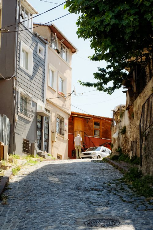 Free A picturesque narrow alley with cobblestone pavement, lined with colorful houses under the bright day sky. Stock Photo