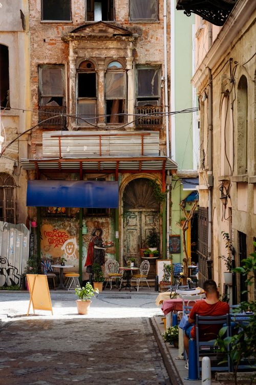 Free Street scene with a cozy cafe next to a historic abandoned building. Stock Photo