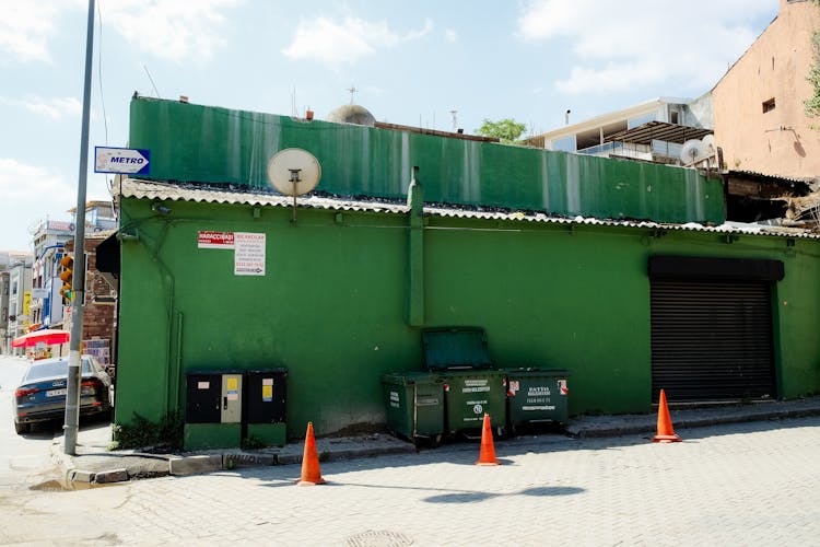 Photo Of A Green Building And Waste Containers