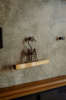 Stylish wire clothes hanger on a textured concrete wall in a vertical shot.