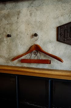 Old wooden hanger on a textured rustic wall indoors with retro style.