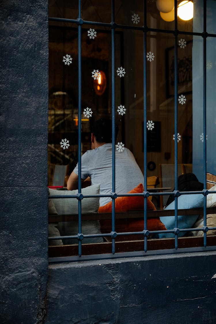 Photo Of Man Sitting With His Back In A Window