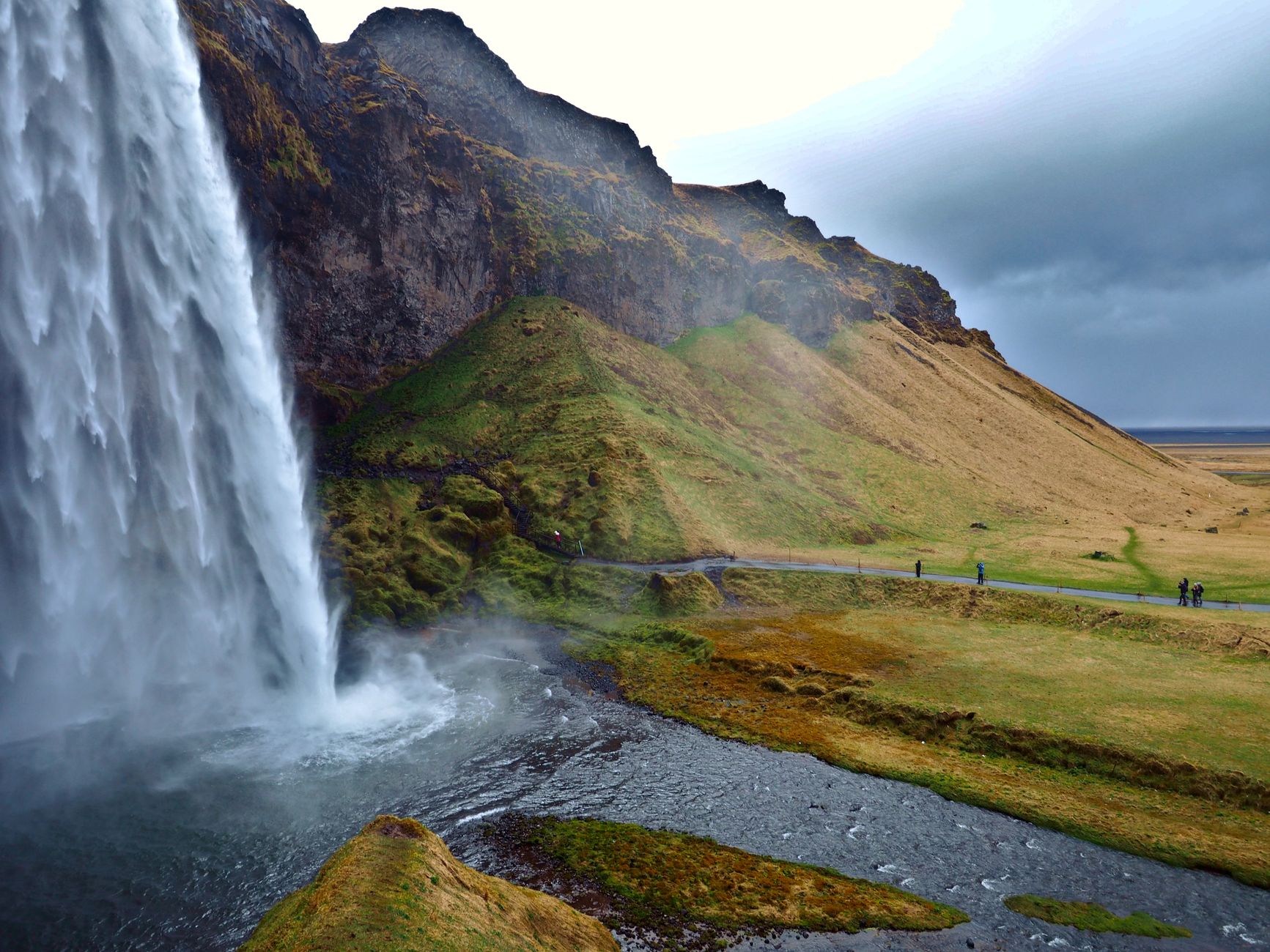 Breathtaking view of Seljalandsfoss waterfall cascading over lush green cliffs in Iceland.