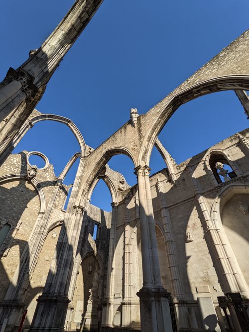 Free Explore the stunning arches of Carmo Convent ruins contrasting against a clear blue sky in Lisbon, Portugal. Stock Photo