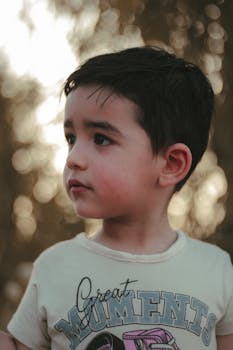 Charming portrait of a young boy with bokeh background, capturing innocence and curiosity.