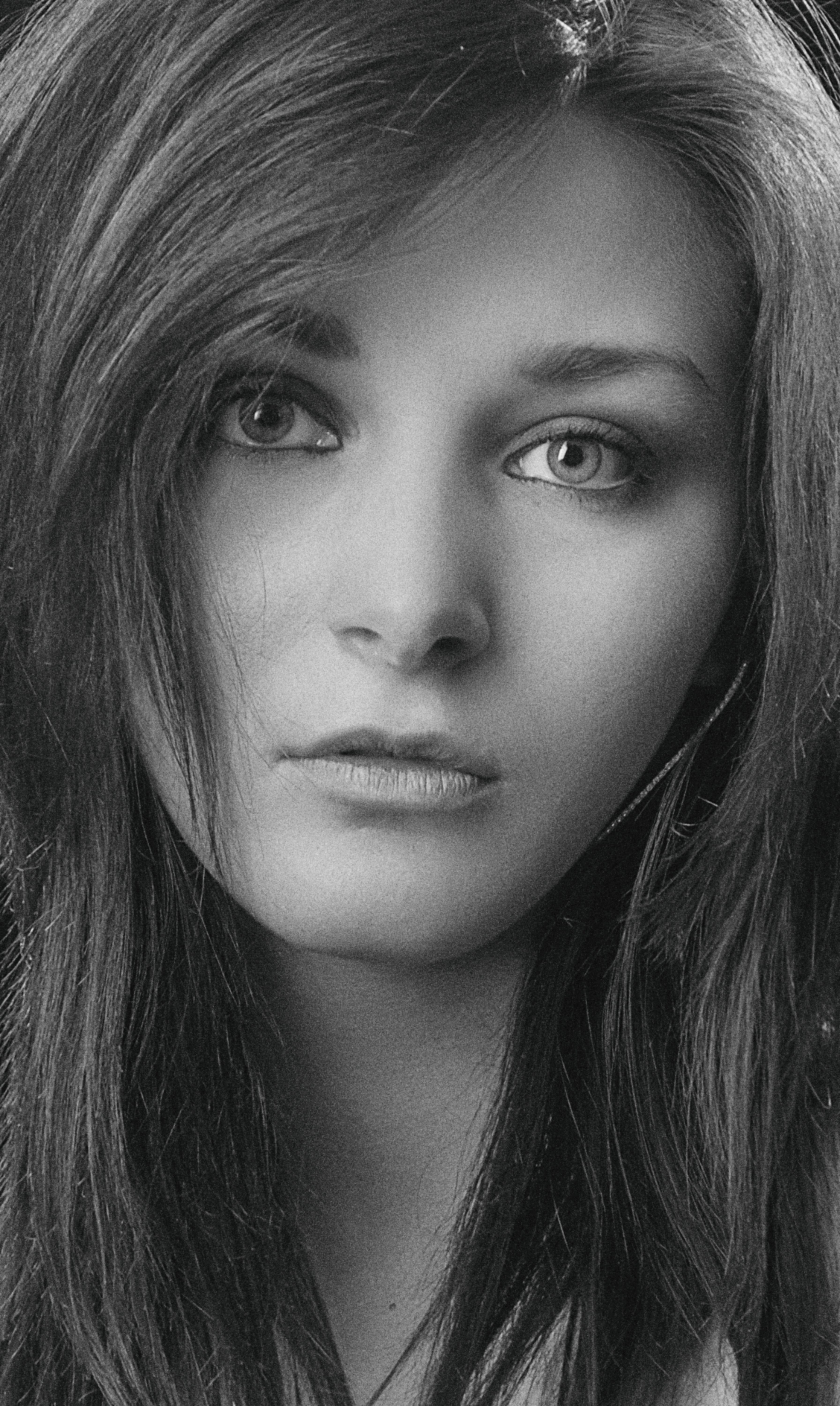 Elegant black and white close-up portrait of a woman with long hair and expressive eyes.