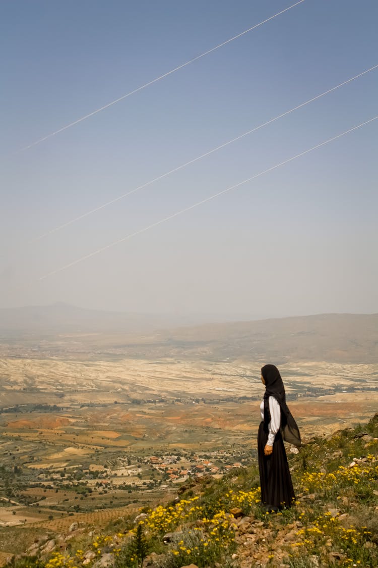 A Woman Standing On Top Of Mountain