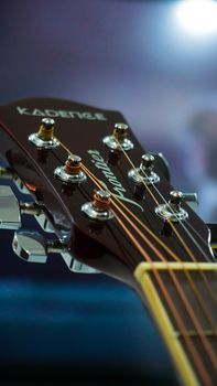 Detailed close-up image of an acoustic guitar headstock showcasing tuning pegs and strings, perfect for music-themed visuals.