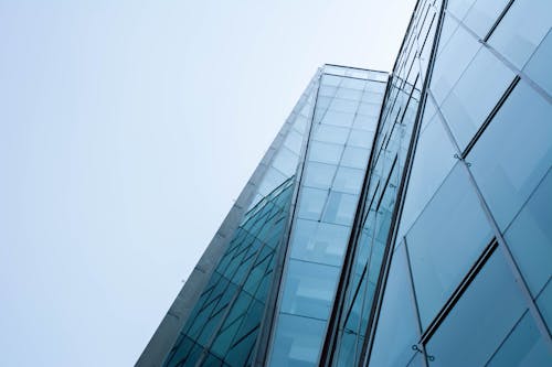 Free Low-Angle Shot of a Tall Glass Building under the Sky Stock Photo