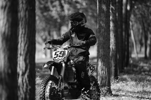 Grayscale Photo of a Person Riding a Dirt Bike