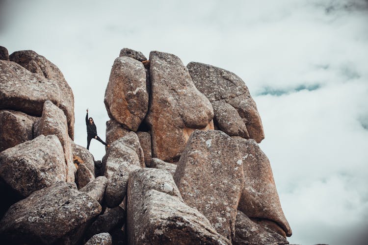 Woman Between Large Stones On Top Of A Rock Formation 