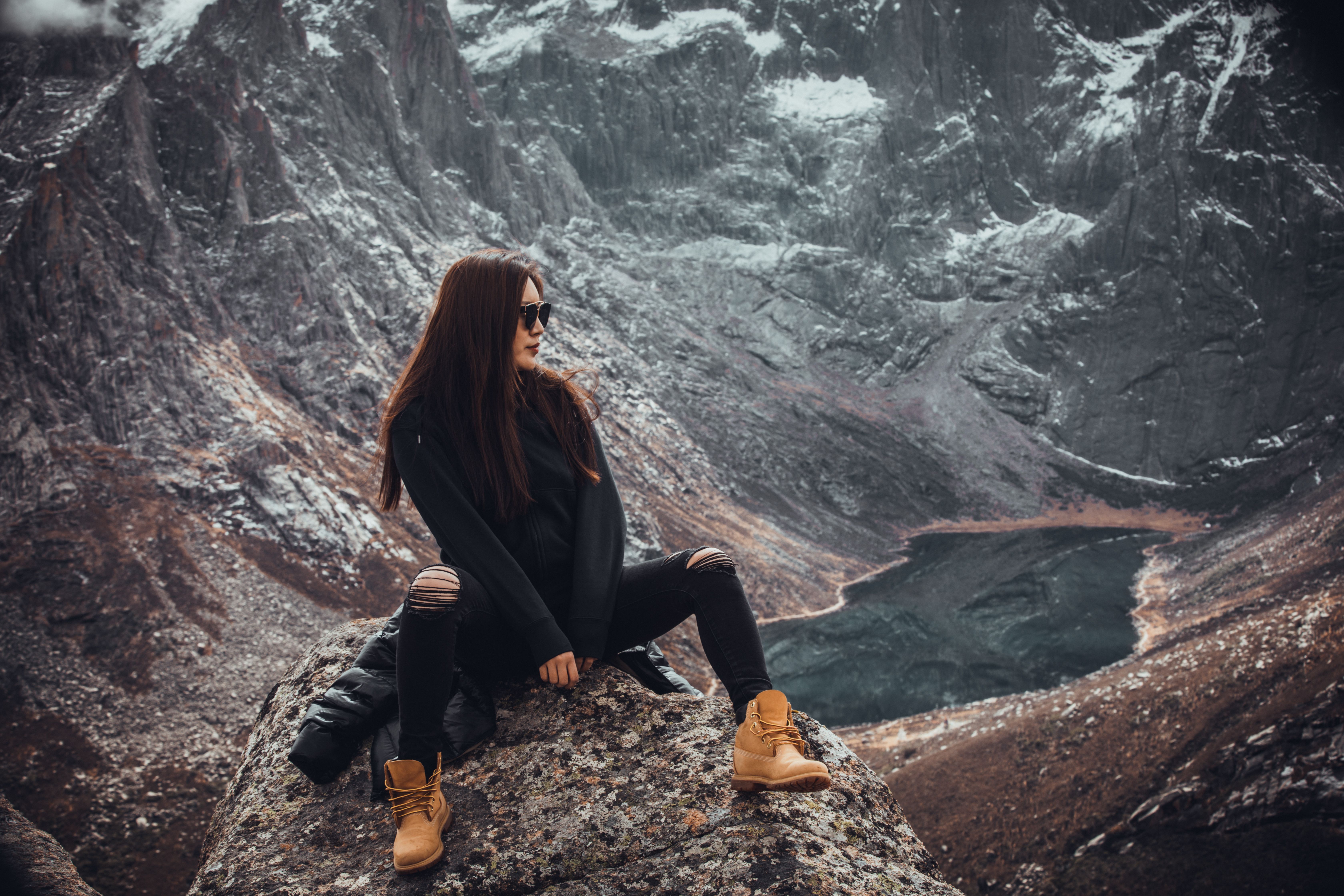 Woman Sitting on Rock Overlooking Lake in Valley · Free Stock Photo