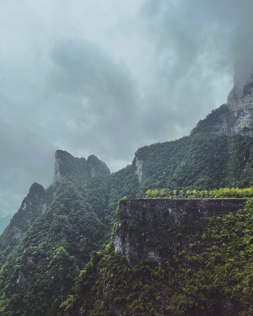 Free Stunning view of the lush green mountains of Zhangjiajie, China, shrouded in mist under a dramatic cloudy sky. Stock Photo