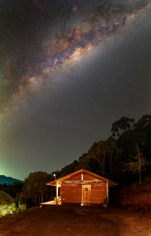 Free Stunning view of the Milky Way over a rustic cabin in Urubici, Brazil, featuring a starry night sky. Stock Photo