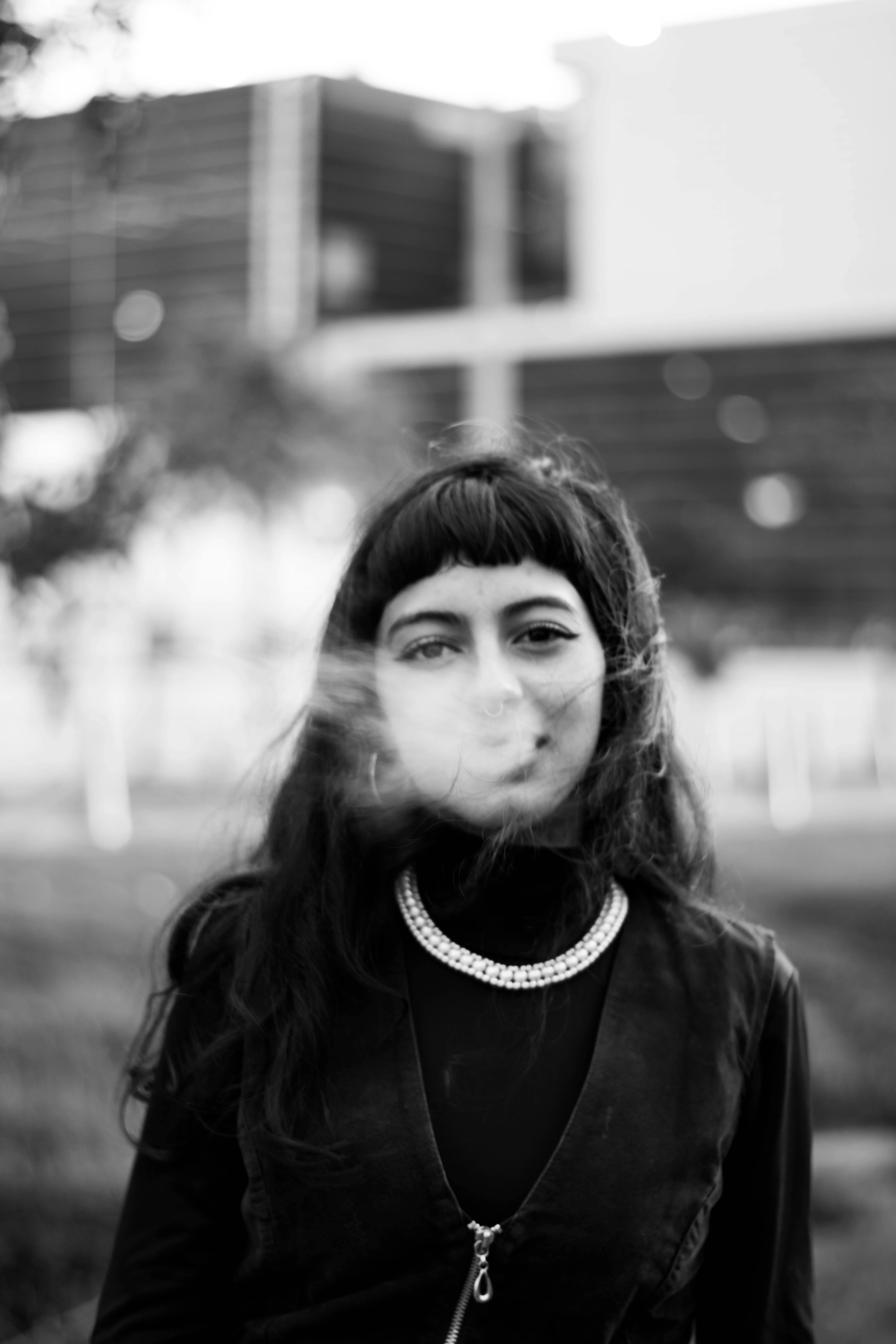 Stylish portrait of a woman outdoors in grayscale, exuding a fashionable aura.