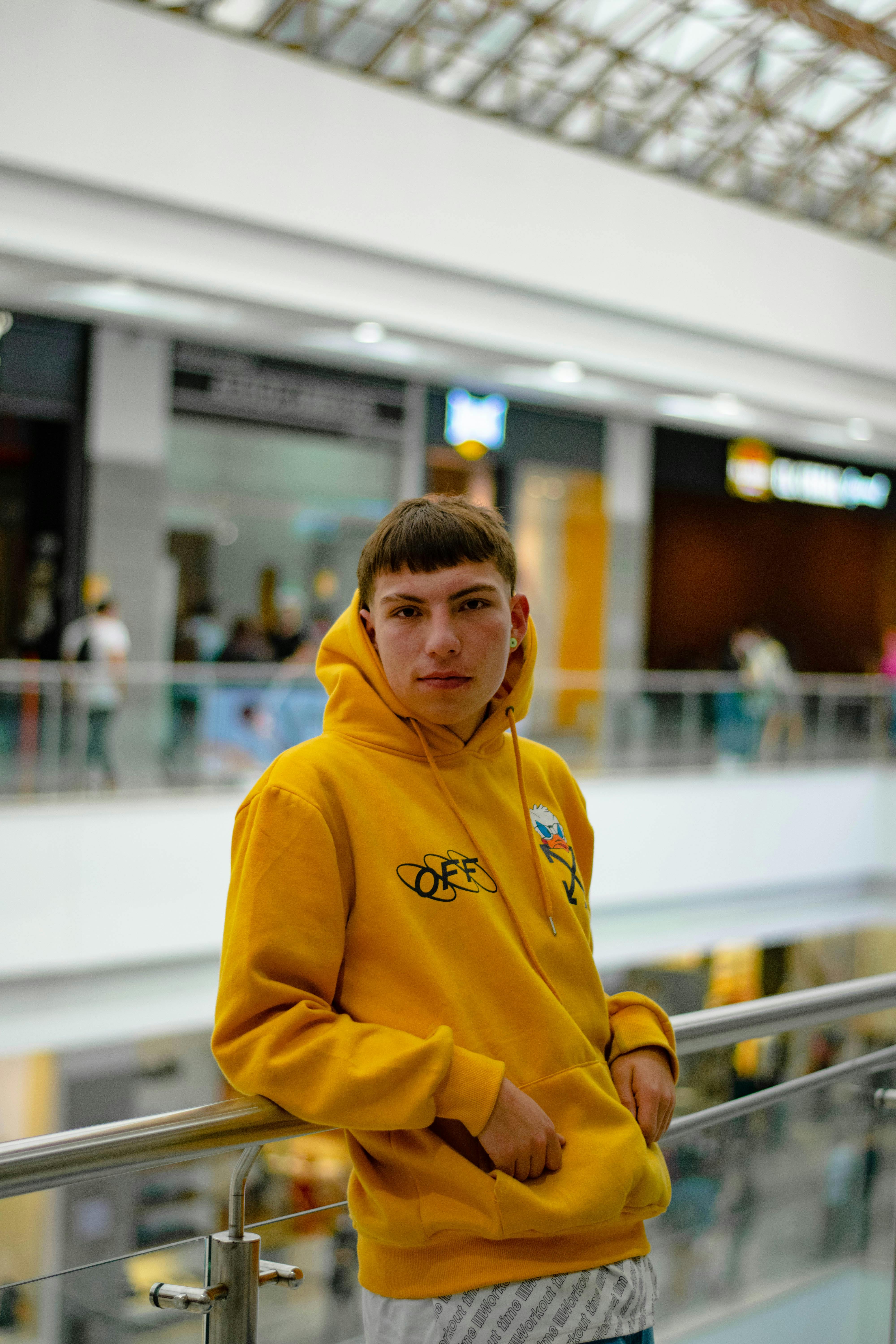 handsome young man in yellow hoodie posing on white Stock Photo - Alamy