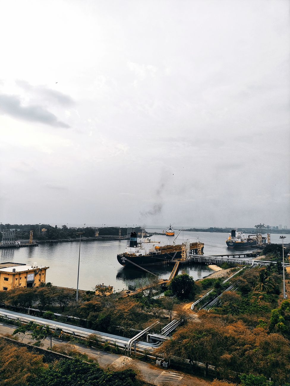 Tankers moored at an oil terminal, illustrating the import bill pressure that is narrowing India's rupee-policy options.