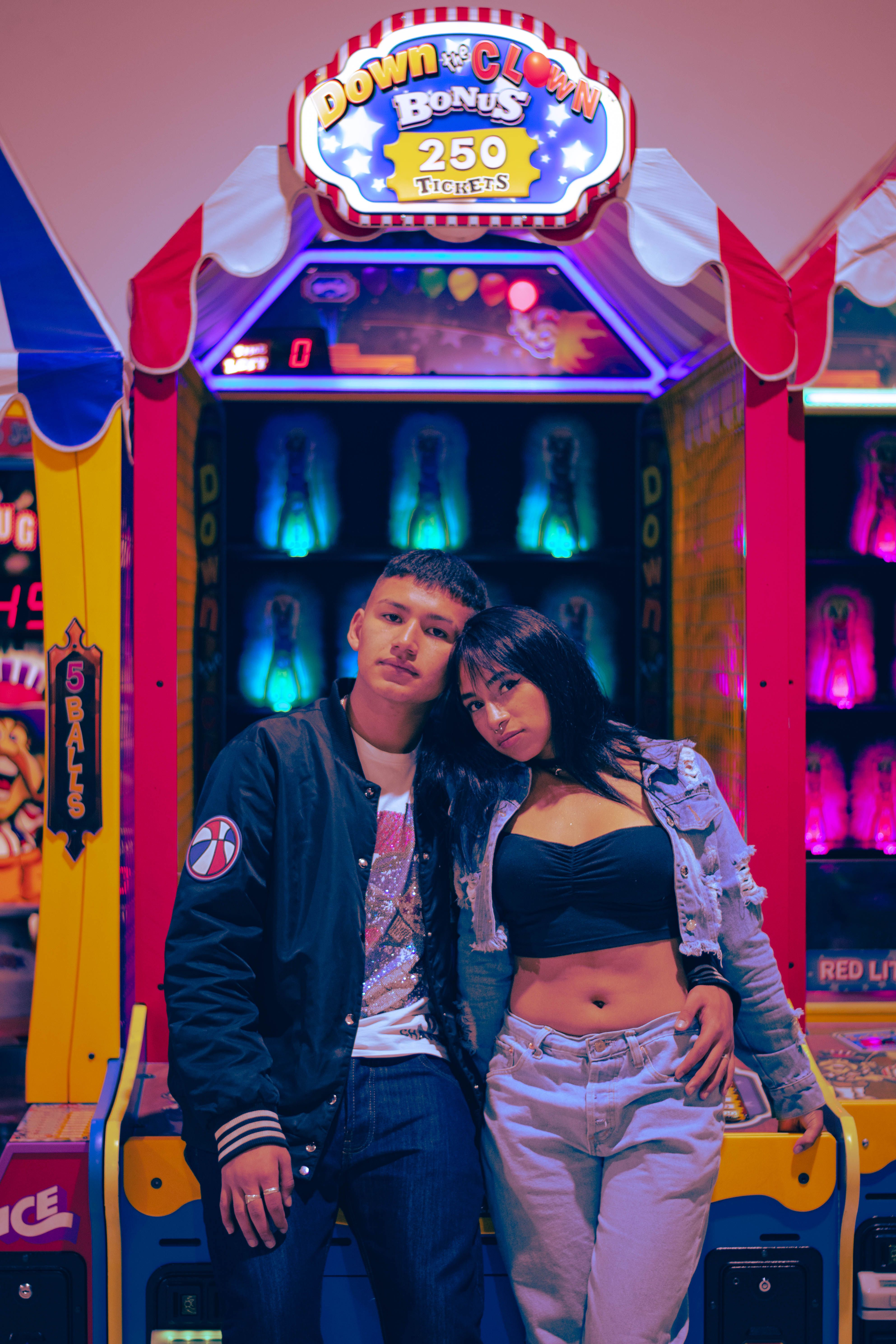 A Couple Sitting on an Arcade Machine · Free Stock Photo