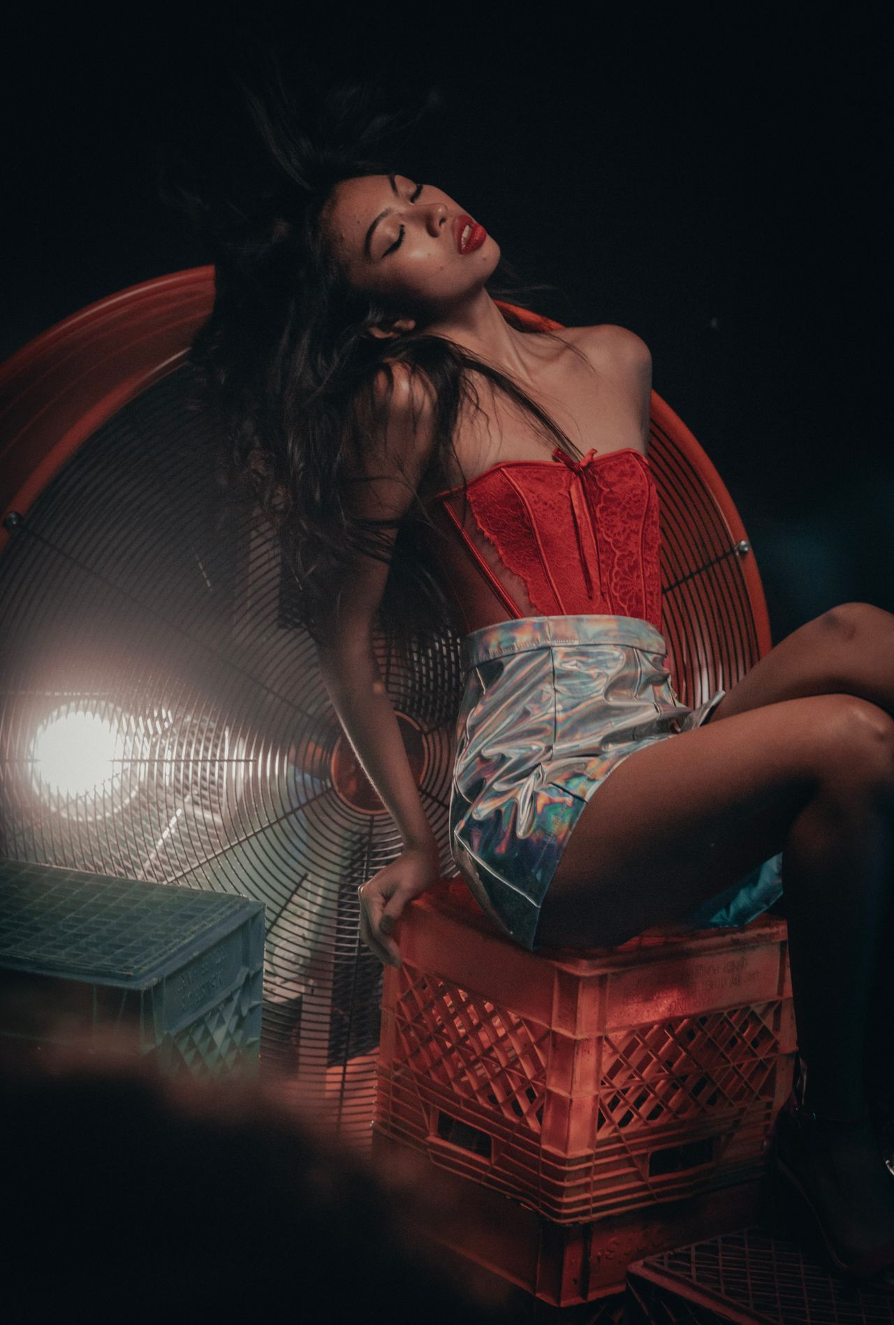 Woman in a red corset top and holographic mini skirt