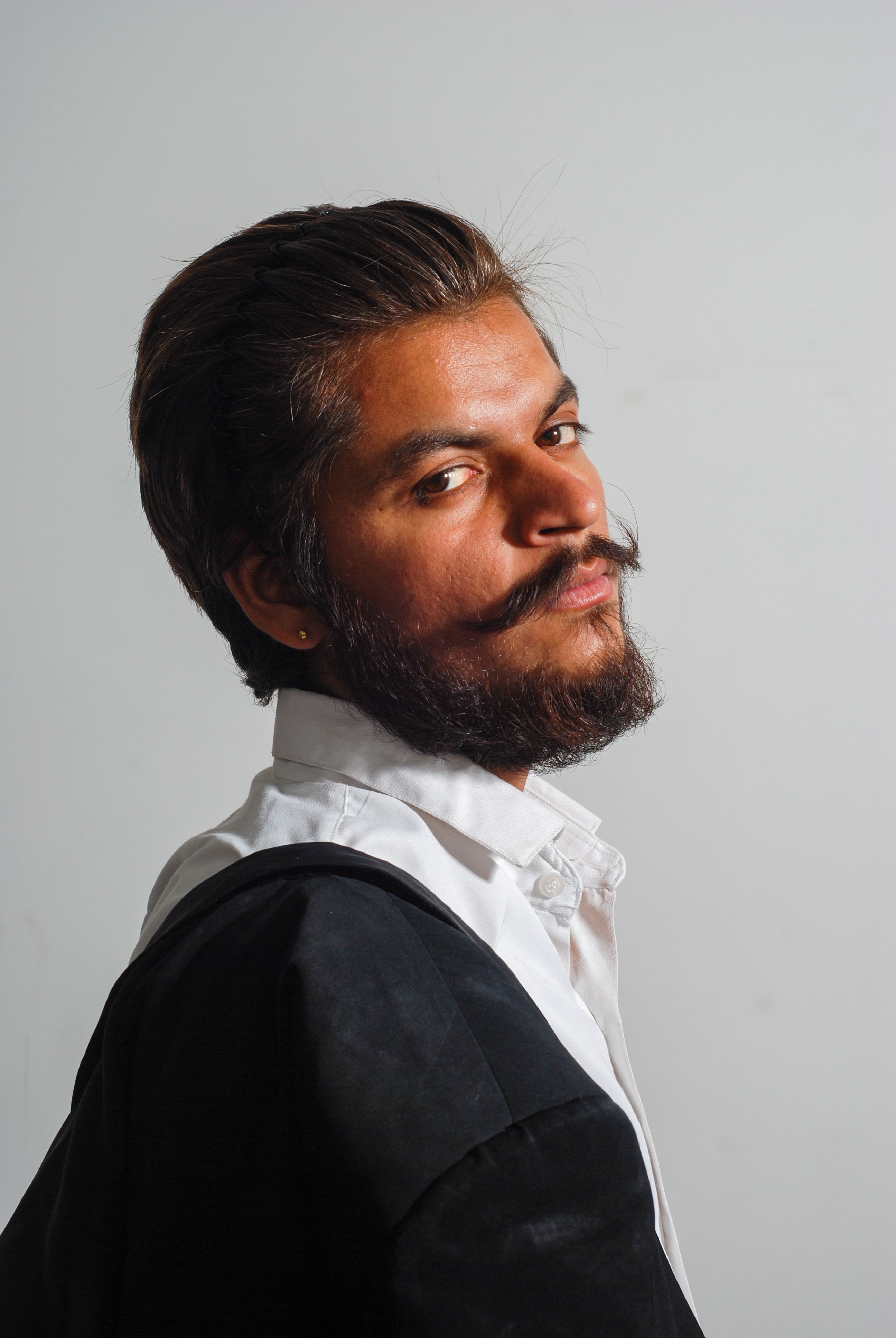 Close-up studio portrait of a serious bearded man in Sahibzada Ajit Singh Nagar, India.