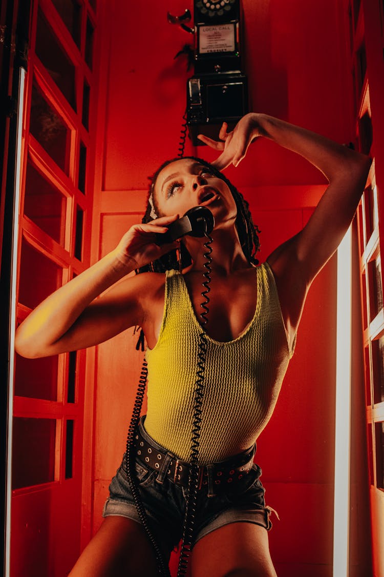 Woman Posing In A Red Phone Booth 