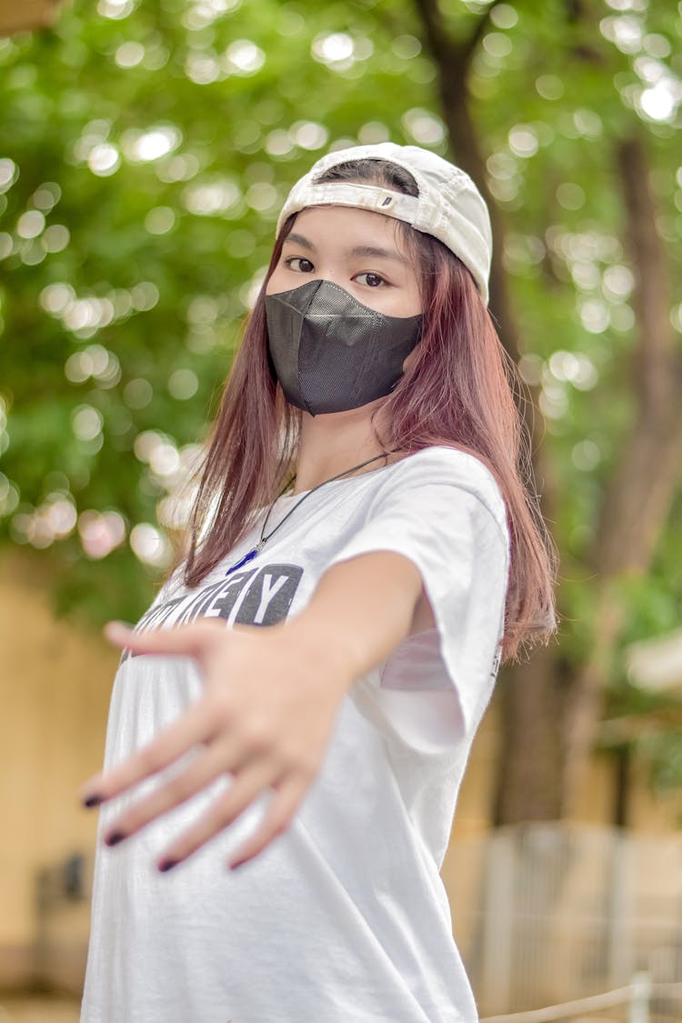 Woman Wearing Face Mask Reaching Hand Out