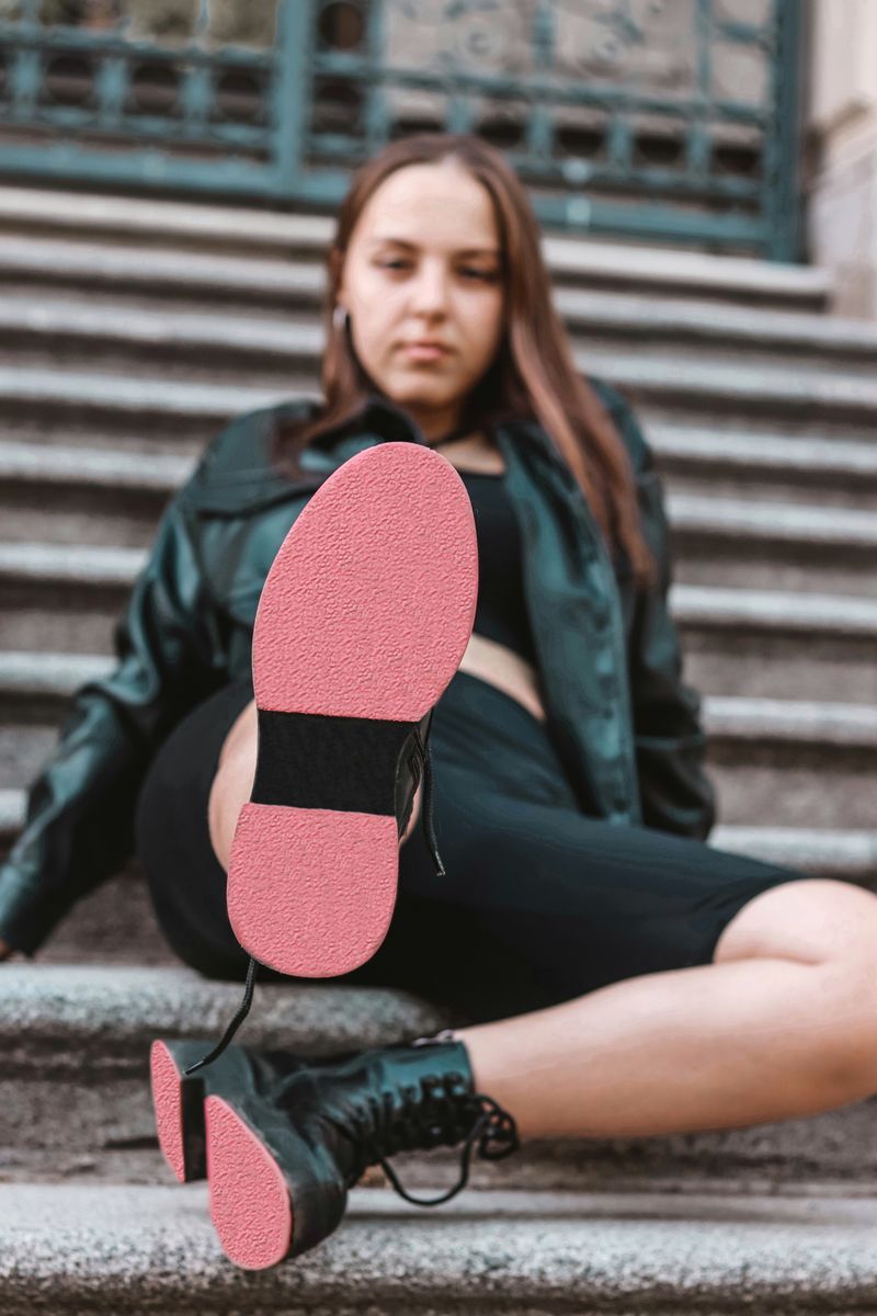 Woman in leather jacket and boots on stairs