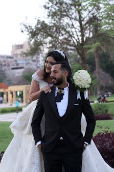 Beautiful wedding couple joyfully embracing in a garden.