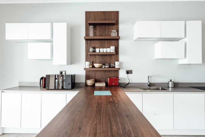 Kitchen with a long walnut counter and white cabinets