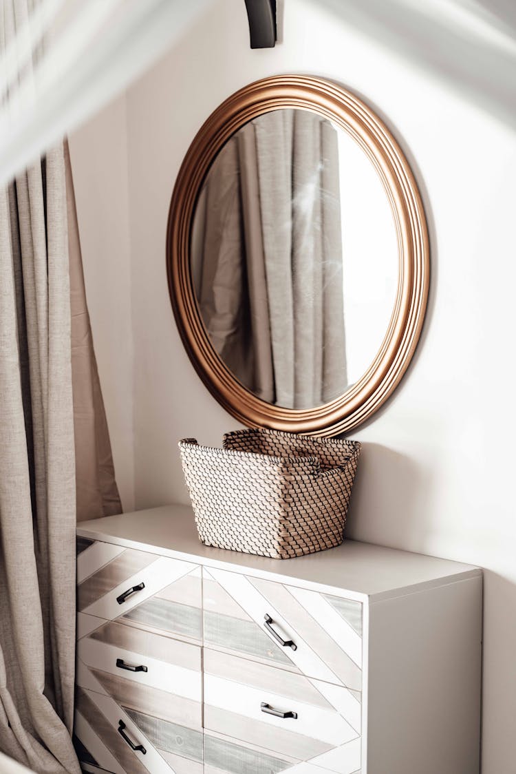 Mirror Hanging On A Wall Above A Drawer