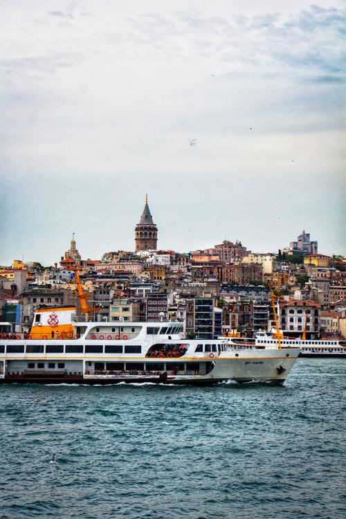 Free Ferry sailing on the Bosphorus with the iconic Galata Tower in Istanbul, Turkey, in the backdrop. Stock Photo