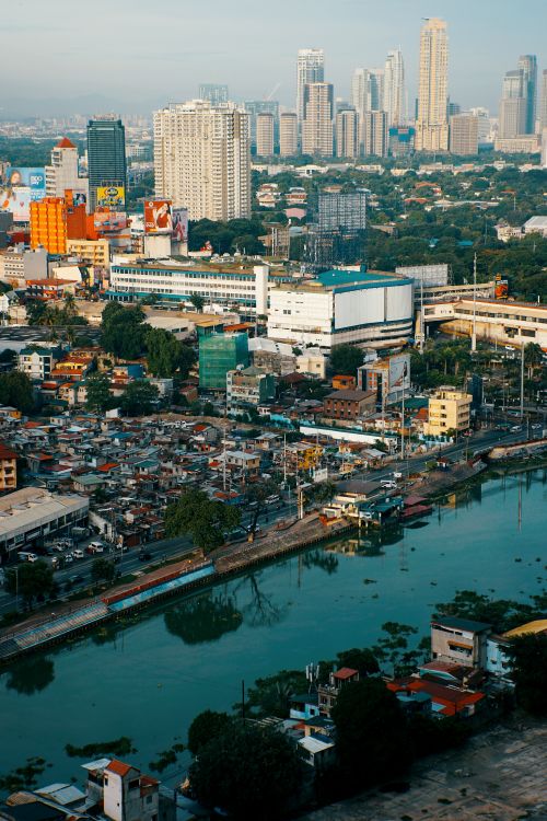 Free Explore the dynamic city skyline with a mix of modern skyscrapers and older buildings near a winding river. Stock Photo