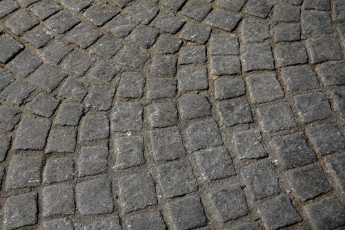 Free Detailed overhead view of gray cobblestone pavement arranged in a circular pattern. Stock Photo